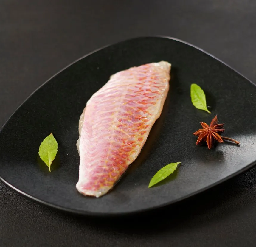 Les filets de rouget, délicatement dorés à la poêle, sont accompagnés d'une garniture légère et parfumée, idéale pour une présentation élégante et savoureuse.