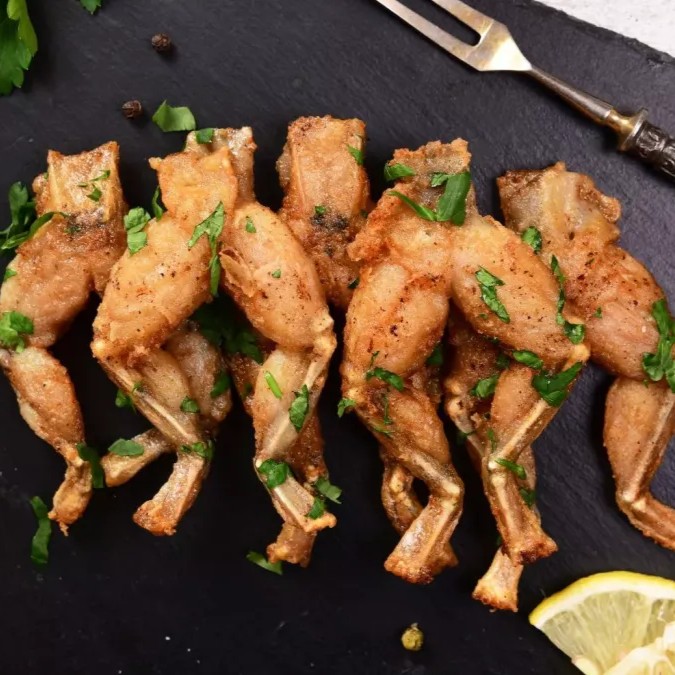 Les cuisses de grenouilles sont un mets délicat et raffiné, emblématique de la cuisine française. Tendres et savoureuses, elles sont souvent préparées avec une sauce à l'ail et au persil, accompagnées de beurre fondu. Ce plat, apprécié pour sa texture délicate et son goût subtil, est généralement servi en entrée ou comme plat principal lors de repas gastronomiques.