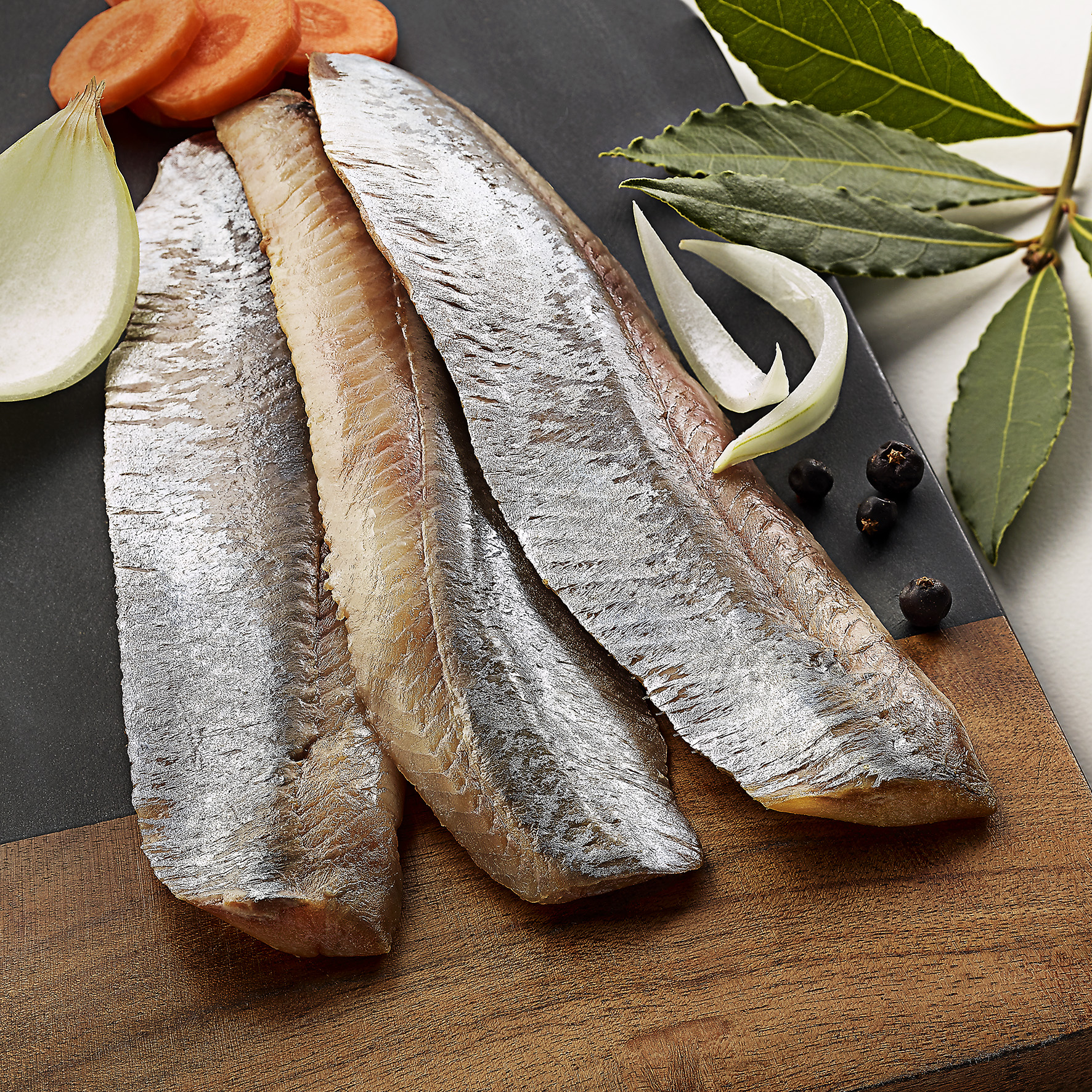 Les harengs doux sont des poissons marinés dans une préparation sucrée qui adoucit leur saveur caractéristique. Ils sont souvent consommés en entrée ou accompagnés de pommes de terre, d'oignons ou de crème fraîche, offrant un équilibre entre acidité et douceur.