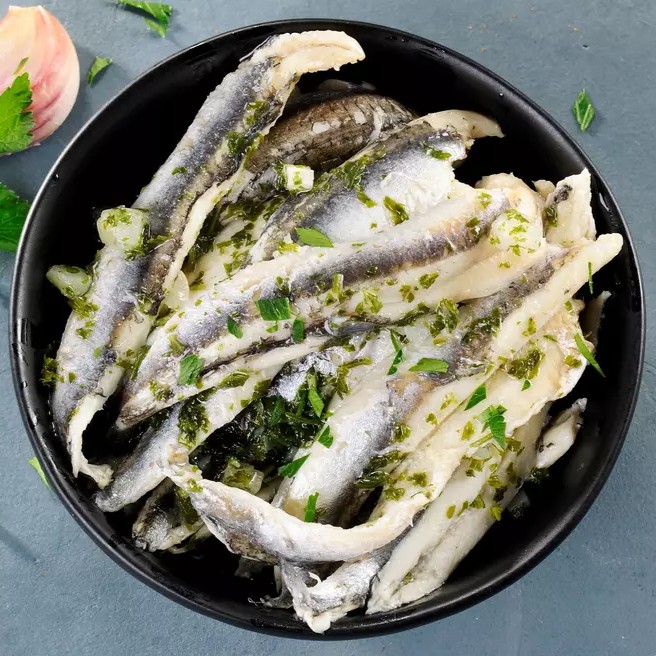 Filets d'anchois marinés à l'huile d'olive, soigneusement préparés pour offrir une saveur riche et délicatement salée. Parfaits pour agrémenter vos plats, apéritifs ou salades.